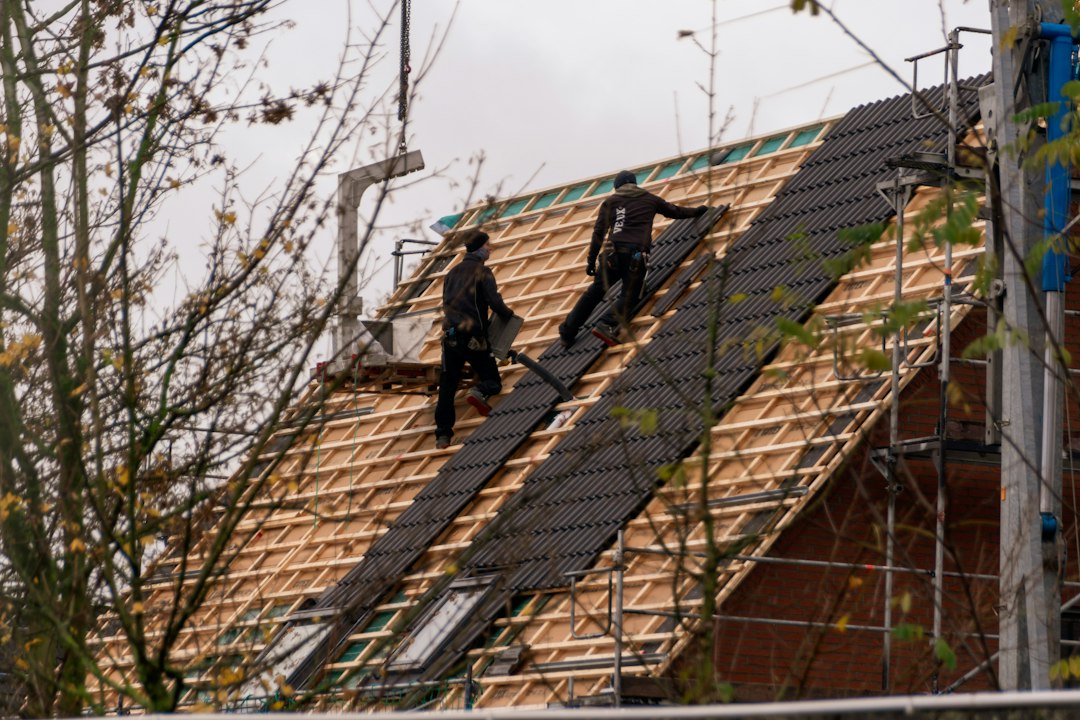 Roofers installing asphalt shingles on a residential roof